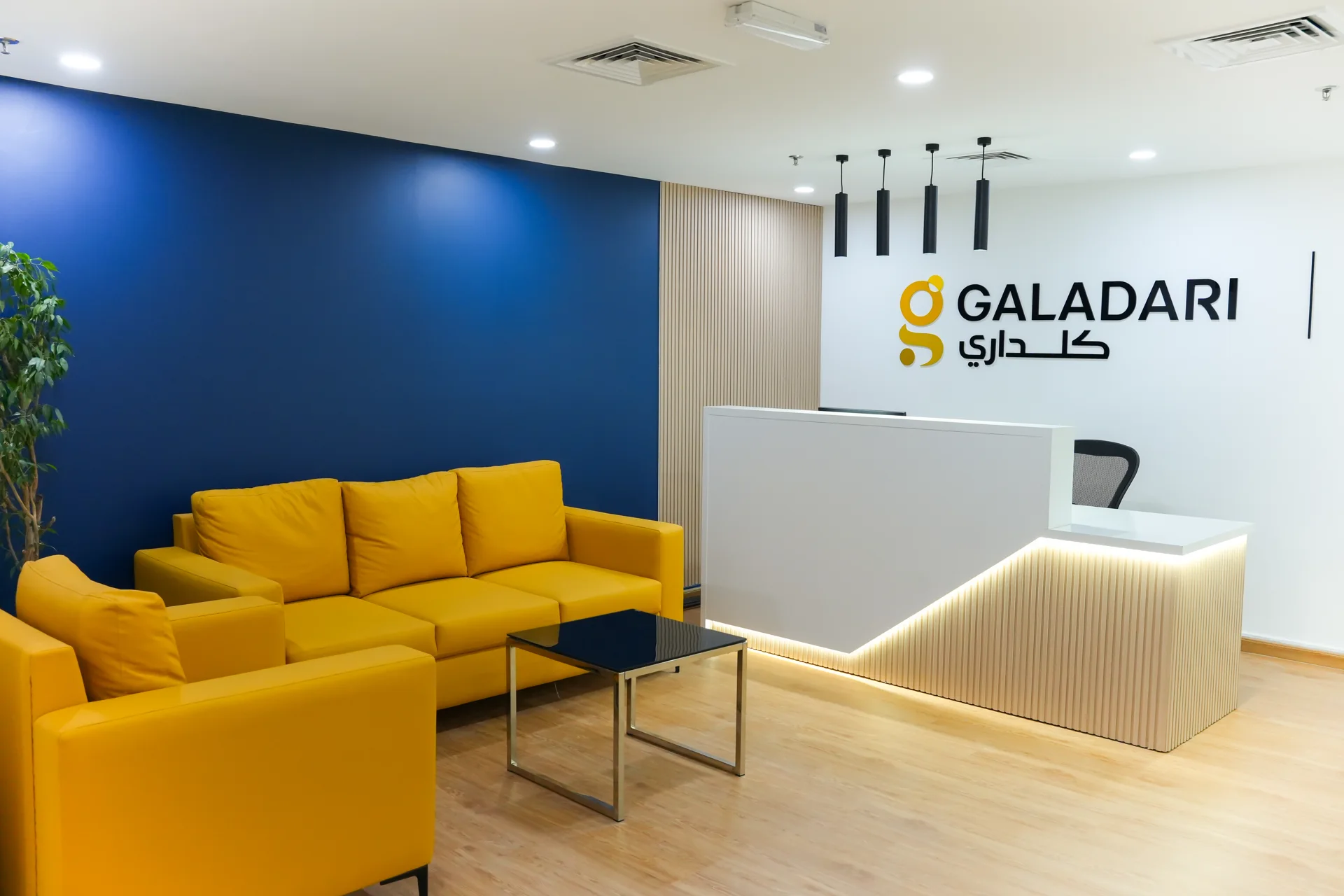 Galadari office reception with mustard seating, blue feature wall and illuminated reception desk