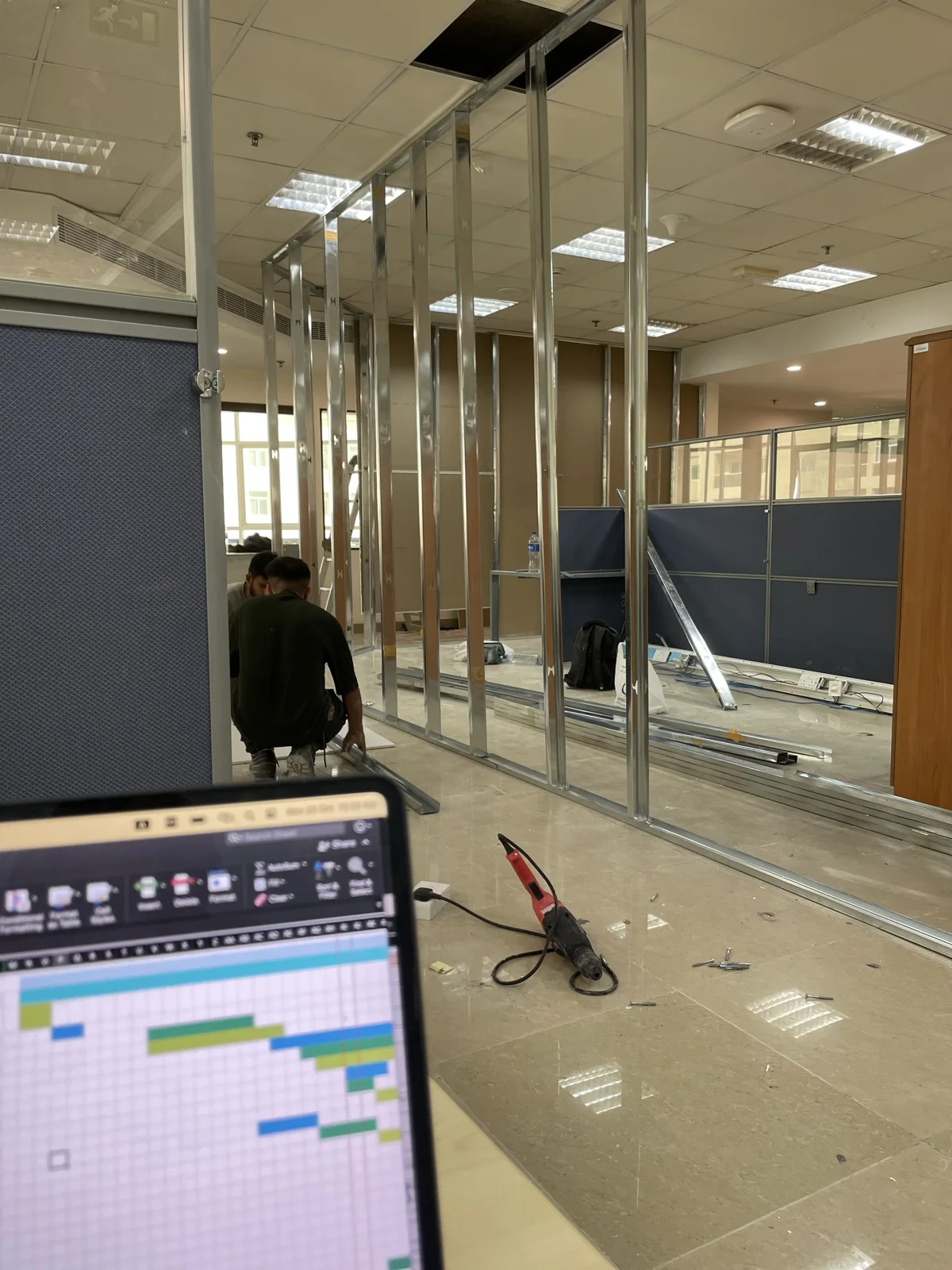 Team installing metal partition framing inside an office